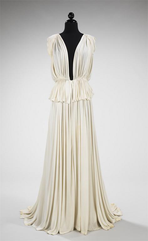 A white gathered evening dress displayed on a mannequin.