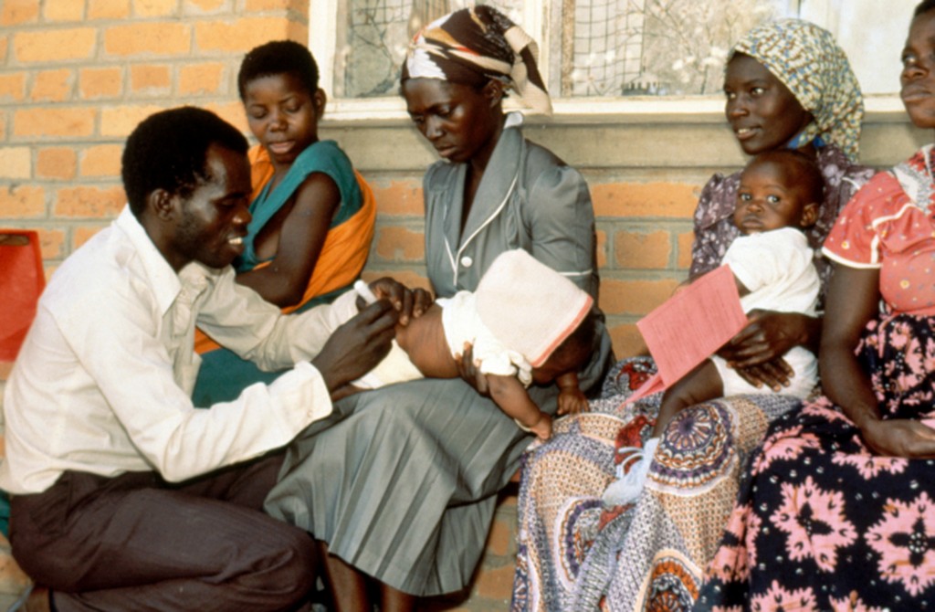 John & Penny Hubley. Child receiving vaccine at fixed site facility Zambia.