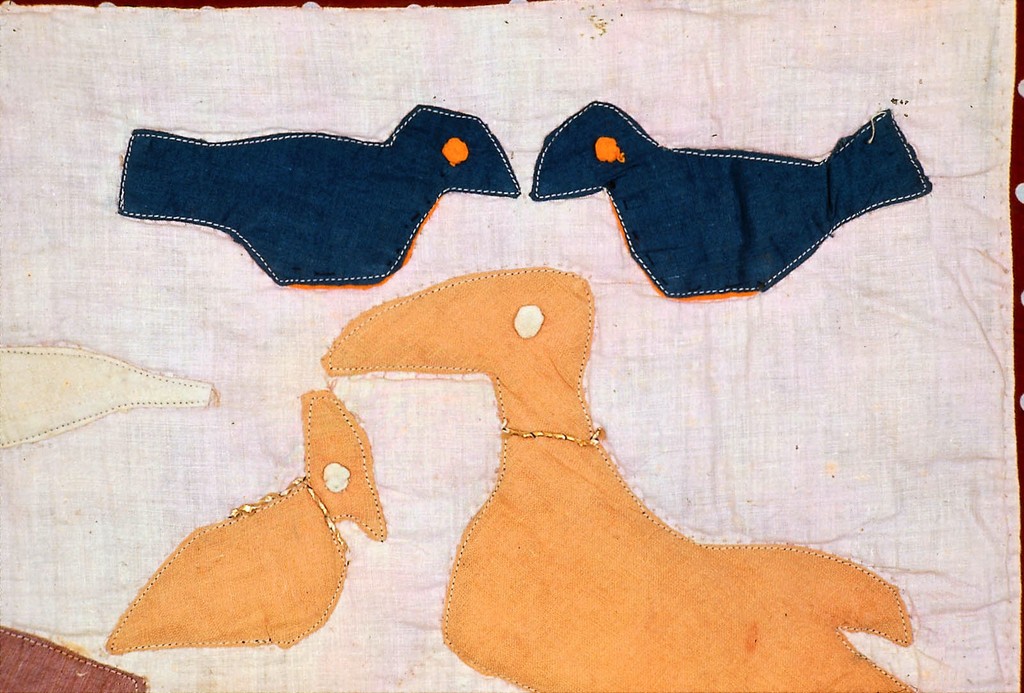 Close detail of colorful quilt appliques of different kinds of birds.