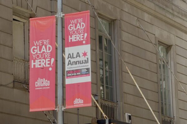 Pink street banners outside a Chicago building welcome attendees to the ALA Annual Conference & Exhibition.